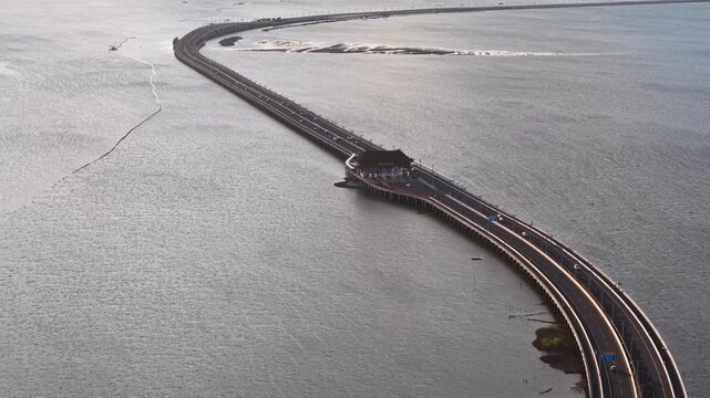 Aerial view of the Mandara Toll Road bridge crossing the water with the toll plaza visible in Kabupaten Badung, Bali, Indonesia.