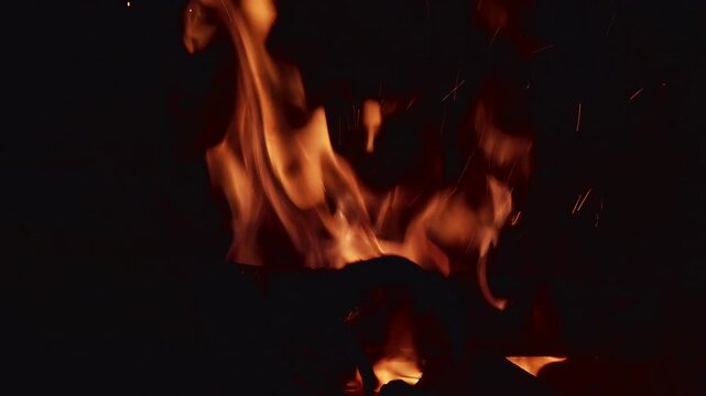 Fire burns brightly in four frames showing flames and sparks during a nighttime gathering with friends around a fire pit in the backyard