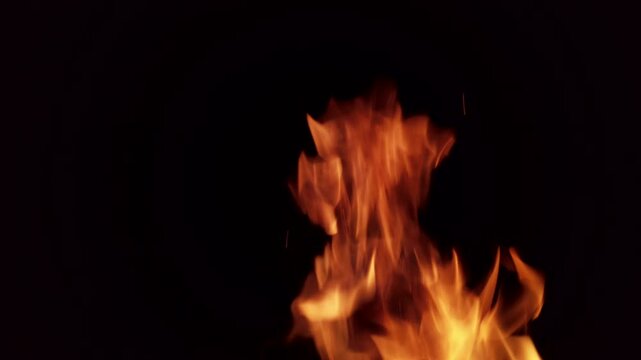 Flame dances in dark room offering simple visual display of fire in four frames showcasing movement and color in a brief sequence