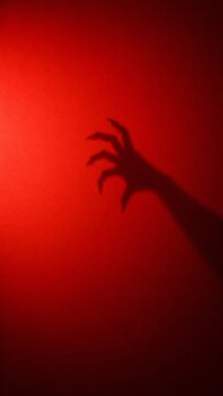 Spooky horror background for Instagram story with creepy monster hand shadow on deep red.