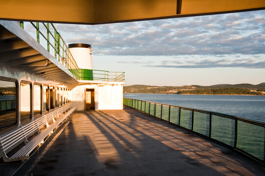 Passenger ferry deck overlooking coastal waters at sunset
