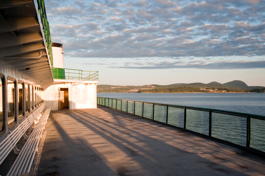 Passenger ferry deck overlooking coastal waters at sunset
