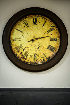 Vintage clock with a weathered design showcasing the city name on the face - vertical