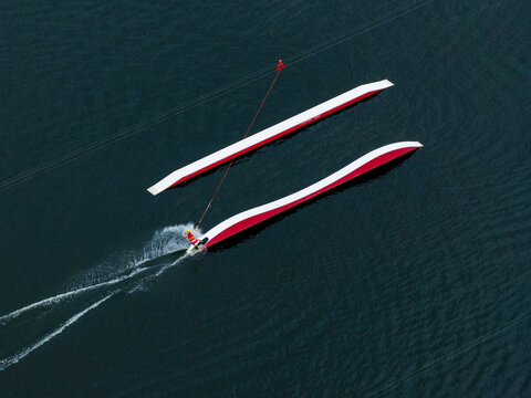 Aerial view of a wakeboarder riding a cable park feature on a lake in Vilnius, Vilniaus apskritis, Lithuania.