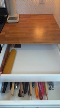 putting away stainless steel cutting boards in a drawer