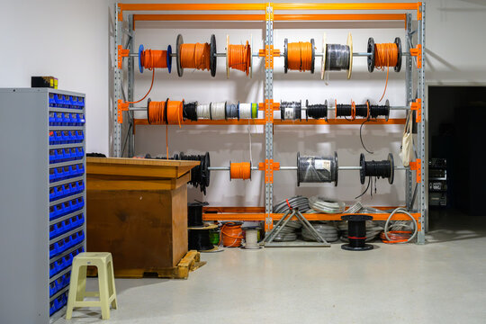 Organized workspace featuring cables and spools on shelving with storage solutions for efficient inventory management - horizontal