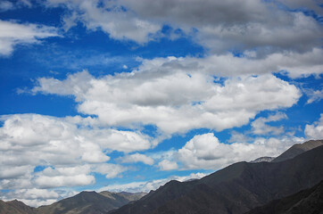 Obraz premium Blue sky with white clouds and mountain range under it