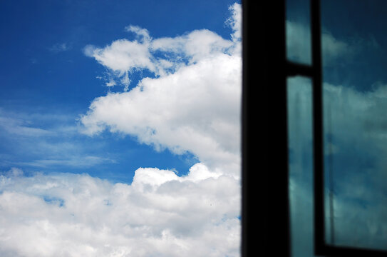 A View of Blue Sky with White Clouds Through Window