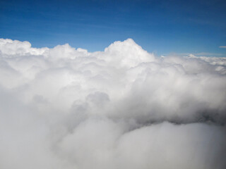 Obraz premium Vast expanse of fluffy white clouds under a clear blue sky