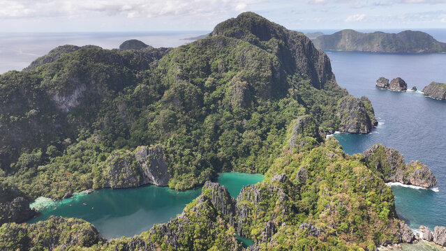 Aerial view of the lush limestone cliffs and turquoise lagoons of Miniloc Island, Mimaropa, Philippines.