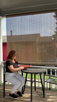 woman pulling out her laptop on the porch