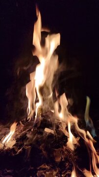 Bright flames burning against a dark background, showcasing intense fire, glowing embers, and dramatic contrast.