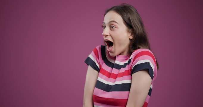 Joyful woman in striped t-shirt laughing intensely against a pink background