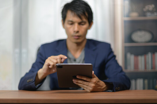 Man in formal attire using tablet computer at home or office setting