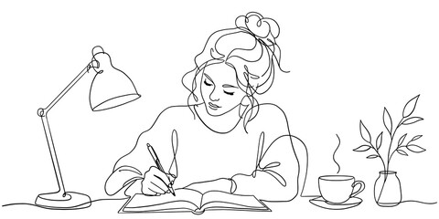 Young woman writing in notebook at desk with lamp and coffee