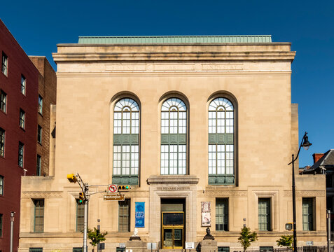 Newark, NJ - US - Jul 26, 2026 The Newark Museum of Art&rsquo;s stately stone facade on Washington Street features tall arched windows, classical detailing, and symmetry beneath a vivid blue sky.