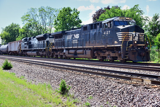 With a buffer car separating the consist from its two lead Norfolk Southern locomotives, a loaded ethanol train moves slowly through the Chicago suburbran area on Union Pacific tracks.