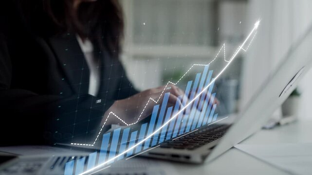 A business professional types on a laptop while an abstract graph overlay signifies growth and success in a contemporary corporate setting, illustrating progress. Copula