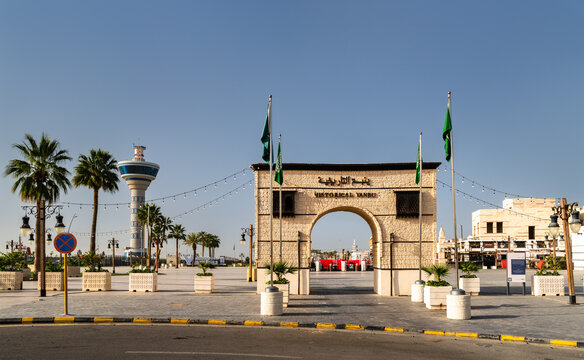 Yanbu, Saudi Arabia - February 17, 2026: The entrance stone archway to the Yanbu Historic Area with Saudi Arabian flags and Port Control Tower in the background.