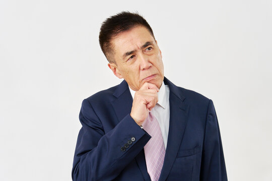 白背景で悩むシニアのビジネスマン