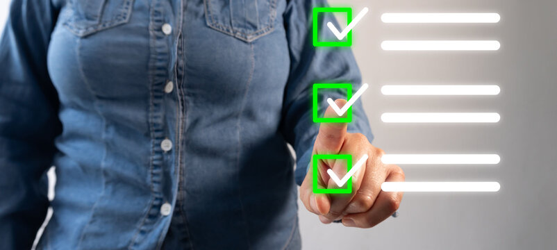 Person in denim shirt checks off tasks on glowing checklist