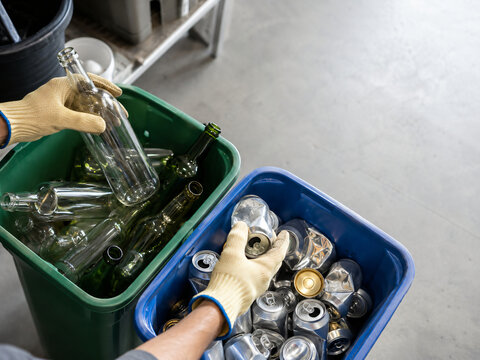 Hands Separating Glass Bottles and Aluminum Cans for Recycling