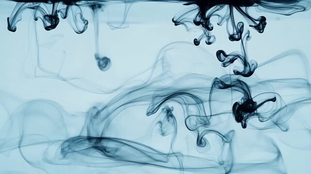 Black ink droplets dispersing in clear water, creating swirling patterns and tendrils