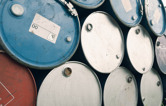 Stack of industrial steel oil drums in warehouse storage yard, petroleum and chemical container background. Fuel logistics, energy infrastructure, manufacturing and industrial supply chain.