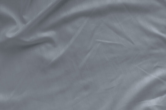 Closeup of white linen bed sheet texture with natural wrinkles. Premium hotel bedding, comfortable sleep environment, luxury bedroom interior, clean fabric background and household comfort.