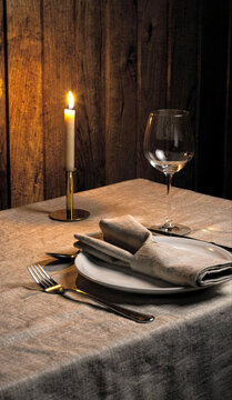 Candlelit Table Setting with Wine Glass and Linen Napkin