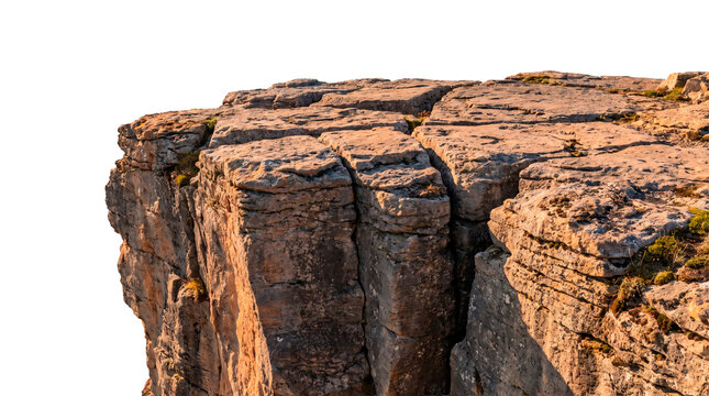 Rugged limestone cliff edge with deep vertical fissures isolated on transparent background