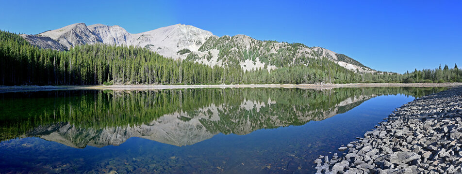 Panorama of Mt Sopris reflected in calm water of second Thomas Lake in White River National Forest near Carbondale, Colorado on sunny summer morning.