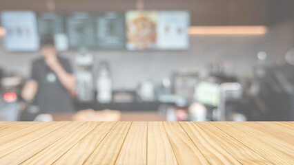 Empty wooden table top with blurred cafe counter and barista background