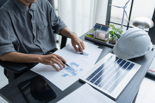 Electrical engineer working on solar panel blueprint sustainable energy