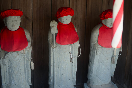 Stone Jizo Statues Wearing Red Bibs And Caps