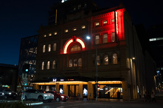 Adelaide, south australia - march 15 2026: Her Majesty&rsquo;s Theatre building glowing with vibrant lights, creating an urban night scene with cars passing by