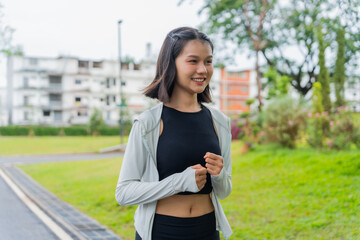 Fototapeta premium Asian sporty woman running in public park