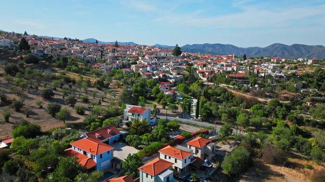 Drone view of Pano Lefkara in Cyprus. The village sits among rolling hills and Mediterranean countryside, with traditional rooftops and mountain scenery.