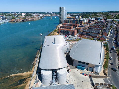 Aerial view of the Woolston Water Treatment Plant featuring modern curved metal roofs and industrial storage tanks situated along the River Itchen in Southampton, England, United Kingdom.