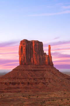 Monument Valley Butte Silhouette at Sunrise with Desert Mist and Vibrant Dawn Sky, Arizona, Utah, US
