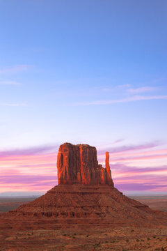 Monument Valley Butte Silhouette at Sunrise with Desert Mist and Vibrant Dawn Sky, Arizona, Utah, US