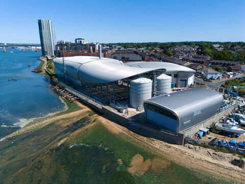 Aerial view of the modern Woolston Water Treatment Plant with its distinctive curved roofs and storage tanks situated along the waterfront in Southampton, England, United Kingdom.