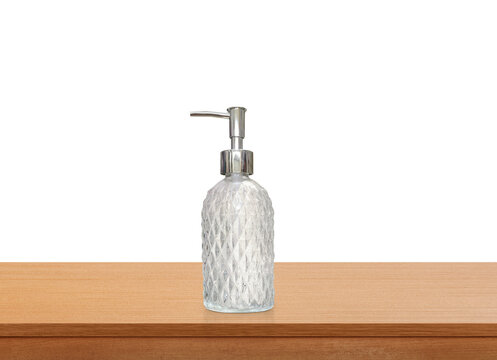A clear glass perfume bottle with a diamond pattern on a wooden table PNG transparent.