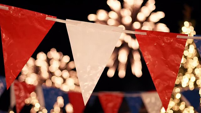 Festive Bunting with Fireworks Background - Red, white, and blue bunting flags are strung across a dark night sky, with blurred fireworks and string lights creating a festive atmosphere.