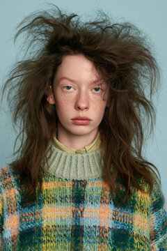 people of ai, yearbook photo of a person with extremely messy long dark-brown hair, bored tired expression, green-orange plaid sweater, photorealistic.png
