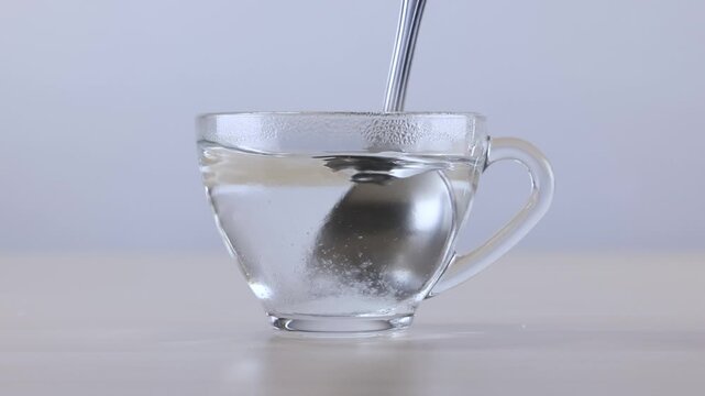 Stirring Sugar into Hot Water in a Clear Glass Cup