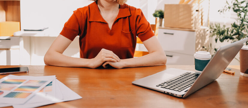 Young woman works on a touchpad, feeling comfortable at cozy home office with a green plant on the background