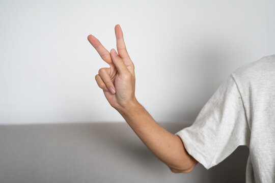 Close up of deaf man using sign language for ASL communication and learning concept.