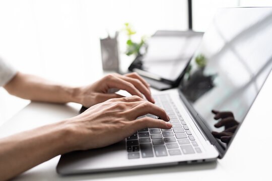 Man typing on laptop keyboard for remote work and digital business technology concept
