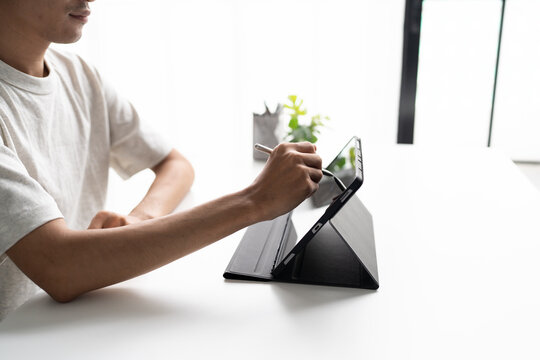 Using stylus on tablet for digital note taking and productivity technology concept.